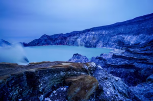 Scenic view of Kawah Ijen crater lake in East Java with turquoise water and rocky volcanic landscape at dawn