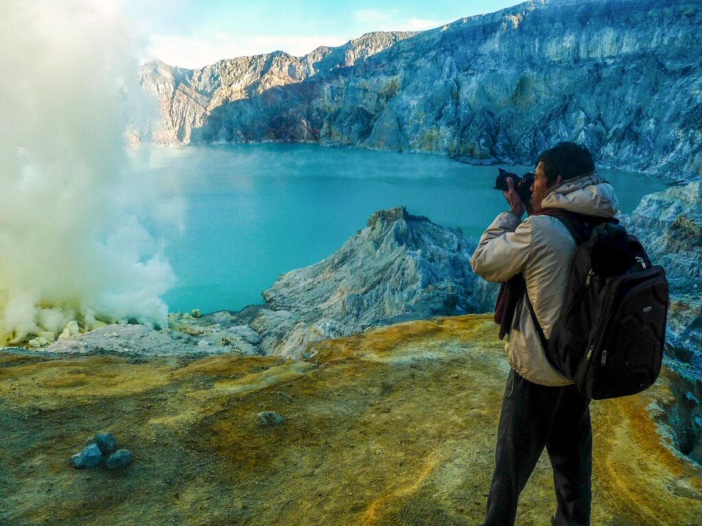 Ijen sunrise photography showing golden light over the turquoise crater lake in East Java