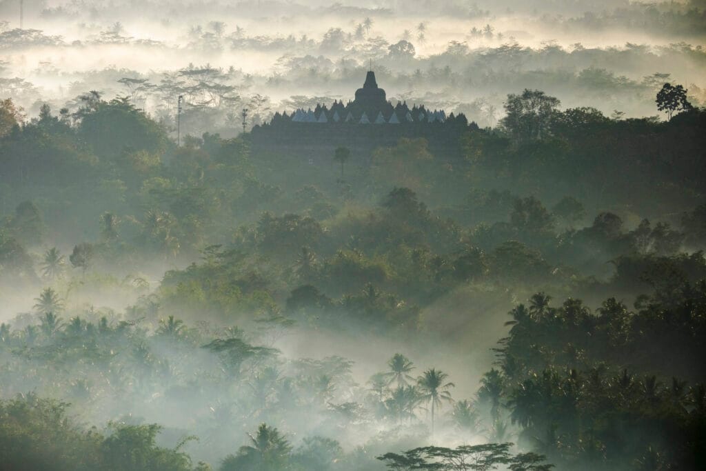 Golden sunrise over Borobudur Temple with misty hills and ancient stupas in Central Java, Indonesia