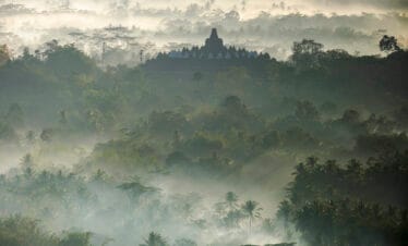 Golden sunrise over Borobudur Temple with misty hills and ancient stupas in Central Java, Indonesia