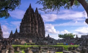 Prambanan Temple complex in Yogyakarta under a bright blue sky, showcasing ancient Hindu architecture during a Yogyakarta temple tour.