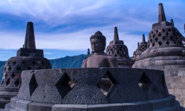 Borobudur Temple stupas standing against a clear blue sky, an iconic stop for travelers exploring Yogyakarta temple tours.
