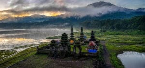 Ulun Danu Beratan Temple in Bali during traditional Balinese ceremonies, surrounded by misty mountains and sacred lake scenery.