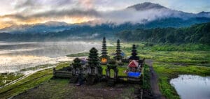 Ulun Danu Beratan Temple in Bali during traditional Balinese ceremonies, surrounded by misty mountains and sacred lake scenery.