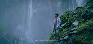 Man standing at the base of Tumpak Sewu Waterfall in East Java