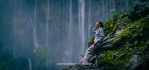 Woman enjoying Tumpak Sewu Waterfall up close in East Java