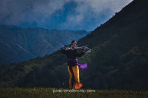 Girls playing violin in traditional Bromo clothing at the volcanic landscape