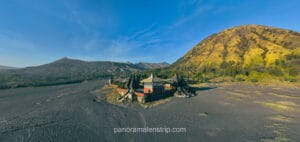 Drone panoramic view of Pura Luhur Poten Temple surrounded by the Sea of Sand and Mount Bromo landscape in East Java, Indonesia.