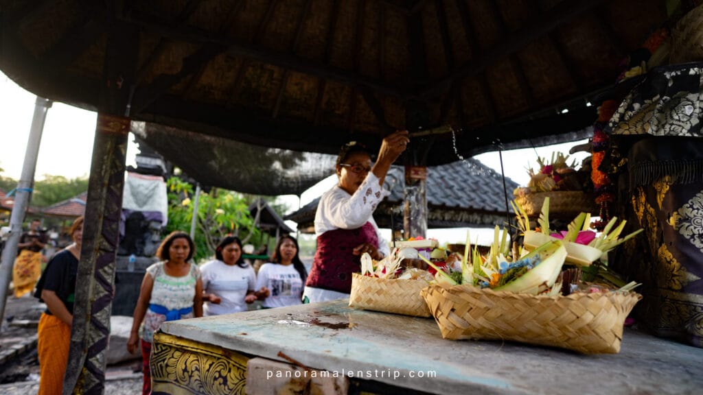 Bali travel tips and tricks showing a traditional Balinese temple ceremony with locals presenting daily offerings and prayers
