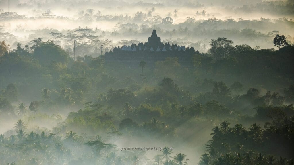 Golden sunrise over Borobudur Temple with misty hills and ancient stupas in Central Java, Indonesia