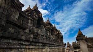 Borobudur sunrise tour close-up of ancient stone relief panels and stupas at Borobudur Temple under a dramatic blue morning sky in Yogyakarta, Indonesia.