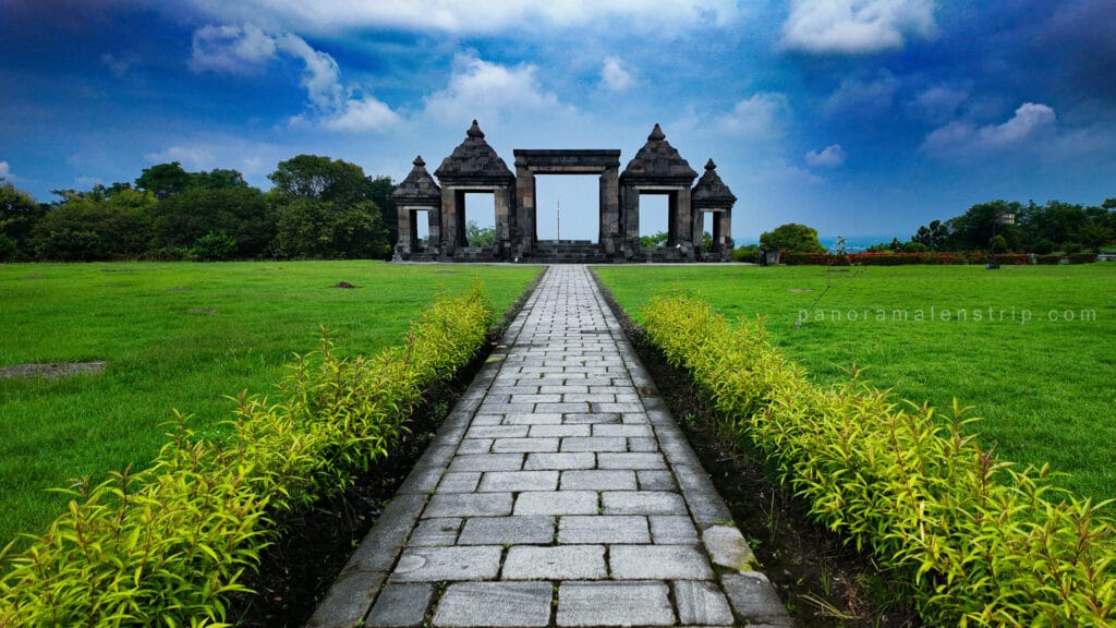 Prambanan photography guide view of symmetrical stone pathway leading to Ratu Boko gate pavilion under dramatic blue sky in Yogyakarta