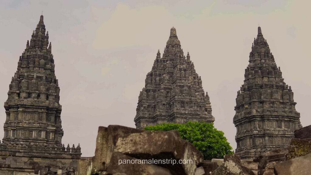 Close-up low angle view of the towering stone spires of Prambanan Temple featuring intricate ancient Hindu carvings.
