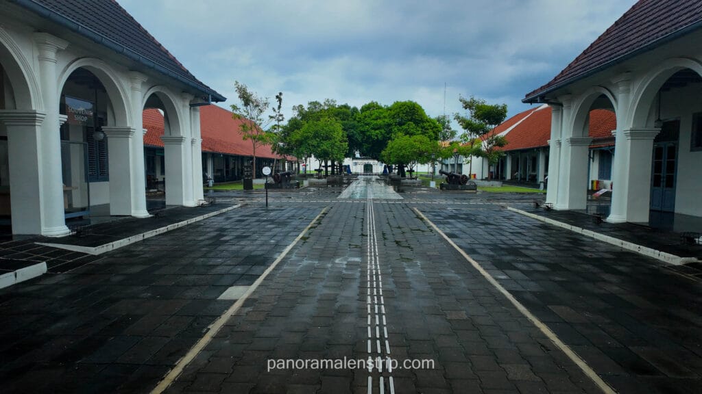 Interior courtyard of Fort Vredeburg Museum in Yogyakarta featuring colonial architecture, white arches, and a paved walkway.