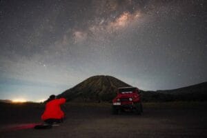 Photographer capturing the Milky Way at Bukit Widodaren in Bromo under a star-filled night sky