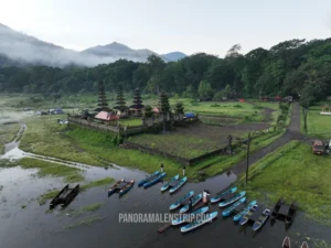 Aerial view of morning ground mist rolling over the pristine waters of Tamblingan Lake during a Bali temple tour.