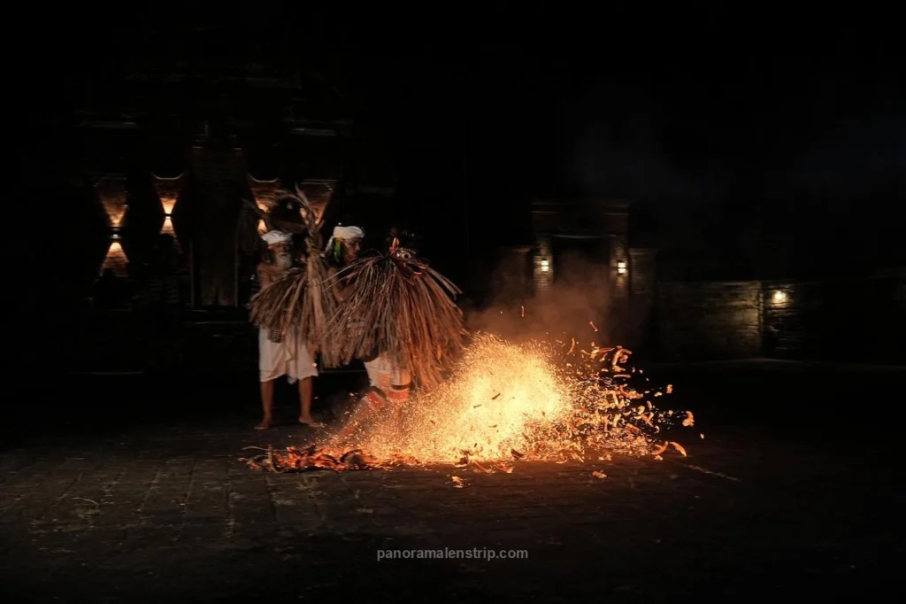An elder guide watches over a young dancer entering a trance state during the Sanghyang Jaran Bali traditional dance ritual.