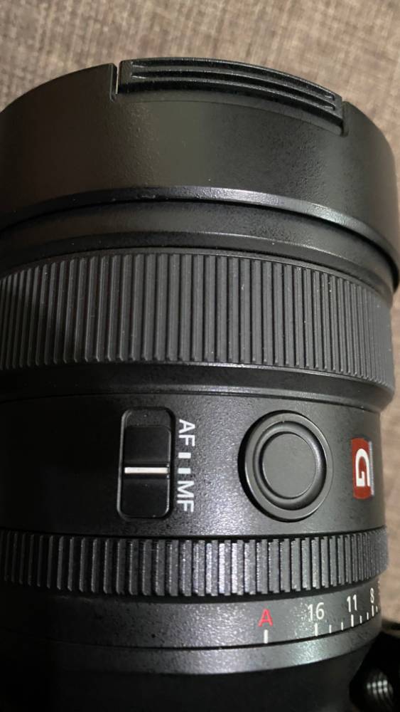 Close-up of a Sony 14mm f1.8 lens set to manual focus, showing the AF/MF switch and aperture ring.