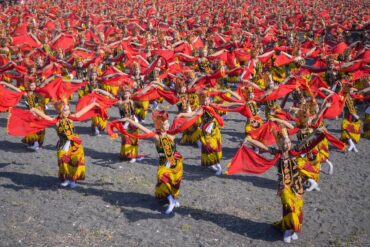 Hundreds of dancers perform the Gandrung Sewu dance in Banyuwangi, waving bright red scarves in unison.