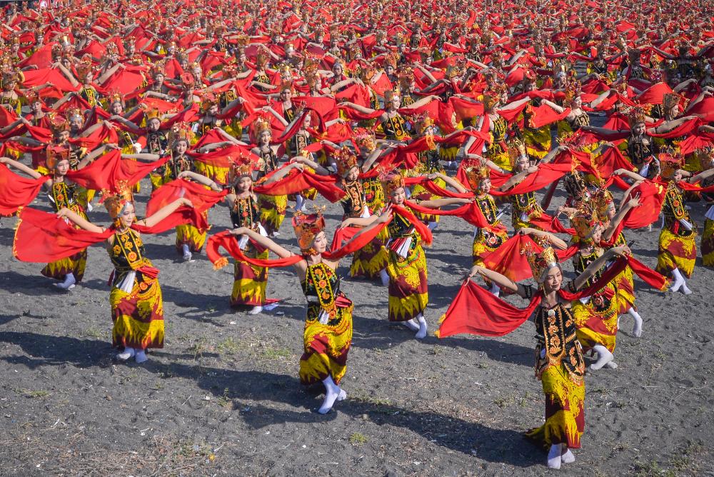 Hundreds of dancers perform the Gandrung Sewu dance in Banyuwangi, waving bright red scarves in unison.